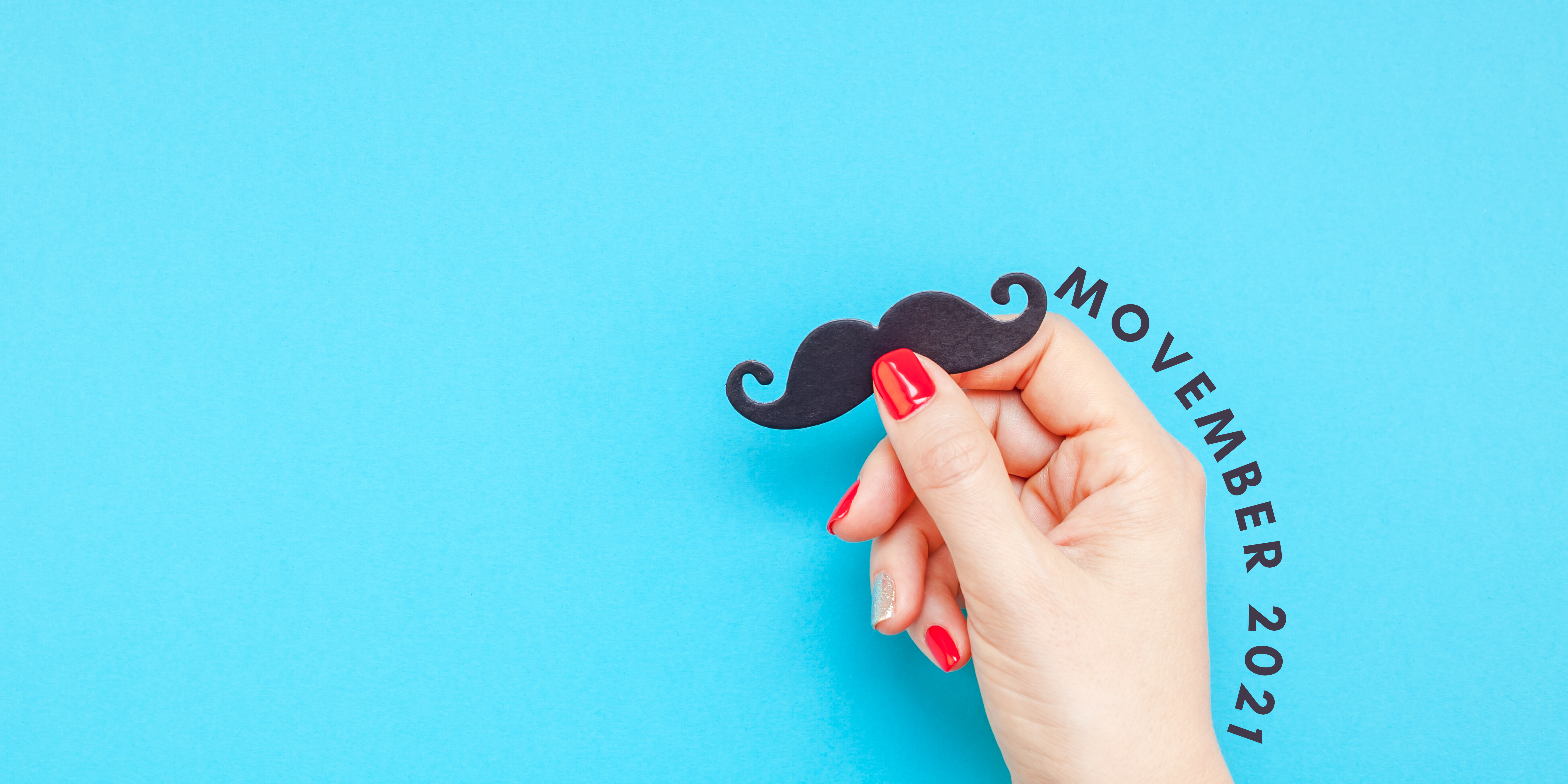 A woman holding a paper cutout of a black curly moustache. Her nails are painted red and silver, and the words "Movember 2021" are written in a curve arouund her hand.
